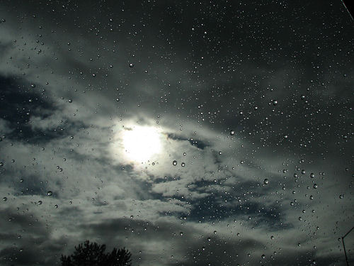 The Sun in Clouds through Rained Window